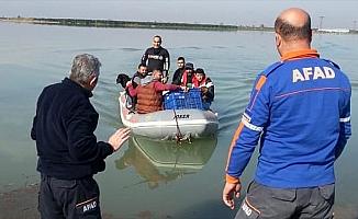 Bahçesi sular altında kalan evden botla kurtarıldılar